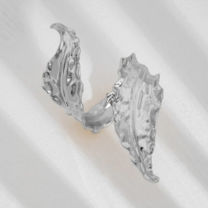 Detailed view of silver liquid metal leaf ring featuring wavy textures on white background