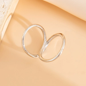 Close-up of polished silver double-ring bangle with minimalist hollow design on stone texture