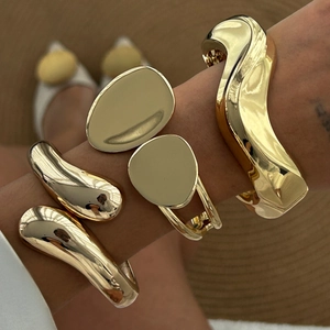 Minimalist gold sculptural open bangle set featuring wavy and waterdrop metal designs