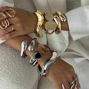 Modern sculptural alloy bracelet and ring set in polished gold and silver finishes