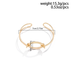 Detail of golden metal open cuff bracelet featuring an oval ring and dual-line band
