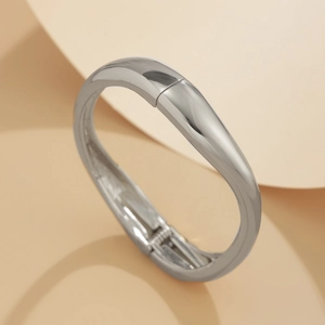 Detailed close-up of a silver hinge cuff bracelet with high-polish metallic finish