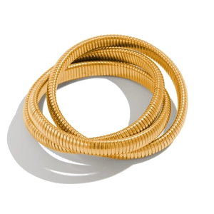 Detailed view of the gold Tubogas spiral bangle featuring a multi-layered metallic texture