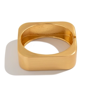 Macro shot of gold square hinge bracelet with brushed metal texture and matte finish