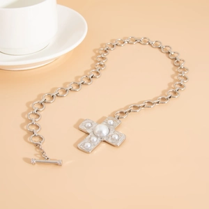 Close-up of vintage cross pendant necklace with pearls and chunky silver link chain