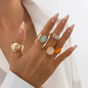 Detail of five-piece vintage gold ring set with colorful acrylic stones on a model