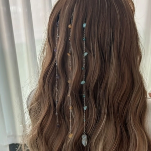Detail of bohemian hair chains with colorful raw stones and silver metal clips on brown hair
