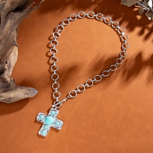 Close-up of vintage silver cross necklace with inlaid turquoise and OT buckle link