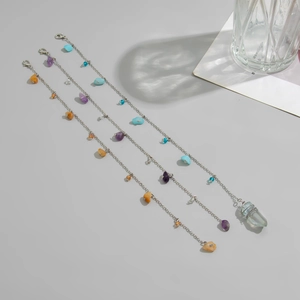 Close-up of silver-plated chains with colorful crushed stones and lobster clasp closure
