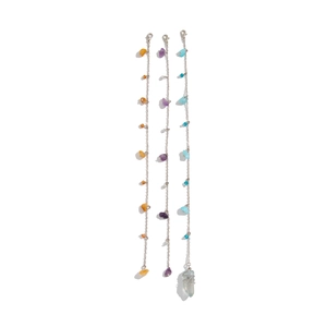 Detail view of silver chains with assorted crushed gemstones and blue crystal pendant