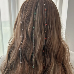 Detail of silver chain hair clips with colorful crushed stones on a model's long hair