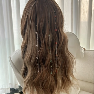 Detail view of colorful crushed stone hair chains on wavy light brown hair