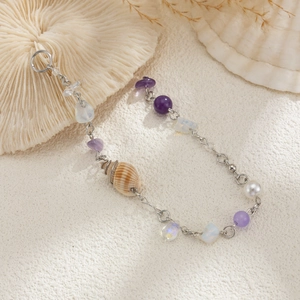 Détail du pendentif conque et pierres violettes sur ce bracelet au thème marin