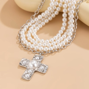 Detail of multi-layer pearl necklace with a liquid metal pearl-studded cross pendant