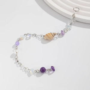 Détail du bracelet en coquillage avec pierres mauves, perles et chaîne en argent pur
