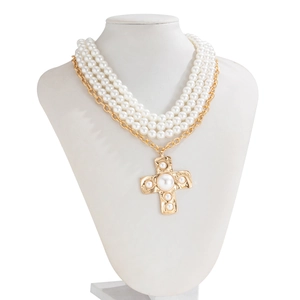 Detail of baroque pearl multilayer necklace with hammered gold cross pendant and pearls