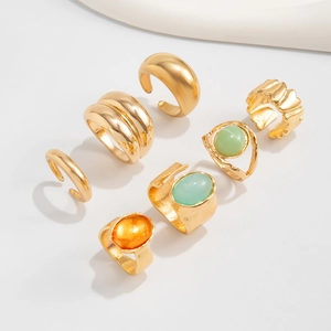 Detailed set of 7 gold-plated rings with gemstone accents on a clean white background