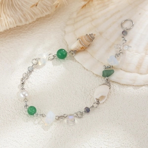 Détail d'un bracelet de plage avec des coquillages et des perles de pierre verte