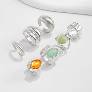 Detailed view of 6-piece silver alloy ring set with orange and green resin oval stones
