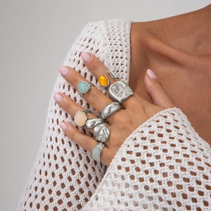 Detailed view of irregular silver alloy rings with colorful acrylic gemstone inlays
