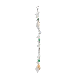 Détail d'un bijou de téléphone avec perles vertes, nacre blanche et petits coquillages