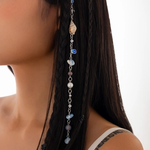 Détail d'une chaîne de cheveux en coquillages avec perles colorées sur une tresse