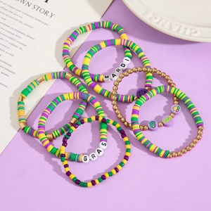 Macro detail of Mardi Gras beaded bracelet set with polymer clay and metallic beads
