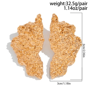 Detailed view of large gold water drop earrings with irregular hammered texture and dimensions