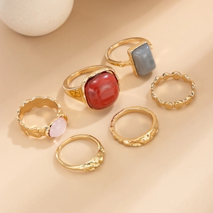 Detail view of 6-piece gold alloy ring set featuring red and grey acrylic stones
