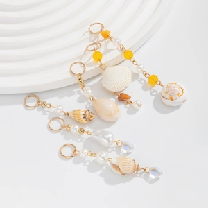 Detail of seashell and pearl hair clip set with gold chain and turquoise elements