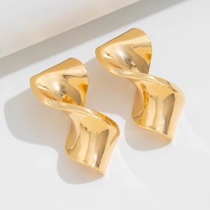 Detail view of wavy golden drop earrings with irregular polished geometric metal surface