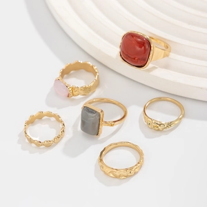 Flat lay view of a 6-piece gold alloy ring set with red and grey resin stone accents