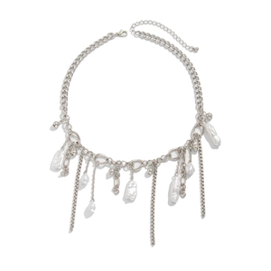 Dettaglio macro di collana in metallo argento con perle barocche e catene a frangia
