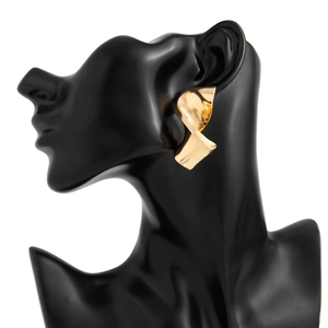 Detail of minimalist gold twisted knot earring displayed on a black mannequin