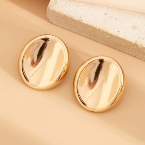Macro view of minimalist irregular oval gold earrings with a polished mirror finish