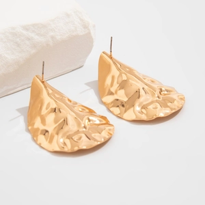 Detail of gold geometric fold stud earrings with unique hammered texture on white background