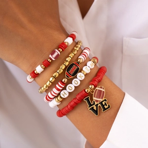 Detail of multi-layer football charm bracelets with red and white beads on a model wrist