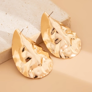 Detail shot of hammered gold-finish waterdrop earrings with irregular rippled metal texture