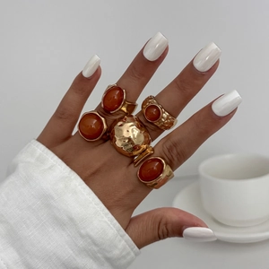 Detailed view of bohemian style gold rings with red gems and hammered metal textures