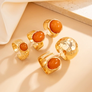 Detailed view of 5-piece gold-toned irregular alloy rings with orange acrylic inlays