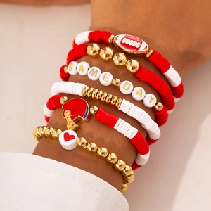 Close-up of stacked Game Day beaded bracelets with red football charms and heishi beads