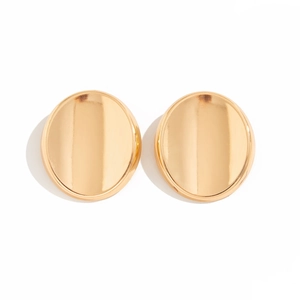 Detailed view of polished oval gold metal stud earrings with mirror finish