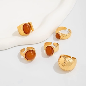 Macro shot of 5-piece vintage gold ring set with amber stones on white display