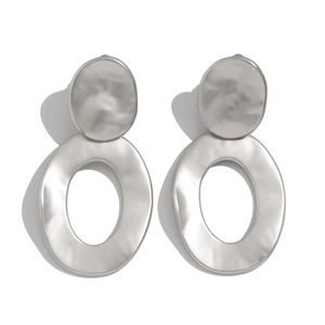 Detail of matte silver drop earrings with a handmade hammered texture and geometric design