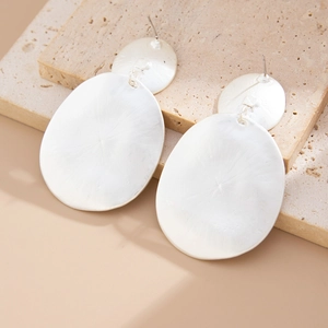 Detail of matte silver tiered teardrop earrings with hammered texture on stone base