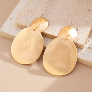 Detailed macro of matte brushed gold double oval drop earrings on stone