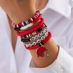 Detail of stacked rugby bracelets with heishi beads and football helmet charm