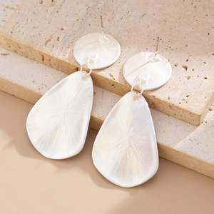 Detailed view of silver drop earrings with irregular hammered texture on stone base