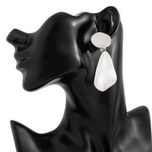 Detail of silver matte geometric water drop earrings on a black mannequin