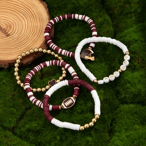 Close-up of Game Day bead bracelets with acrylic charms on natural moss background
